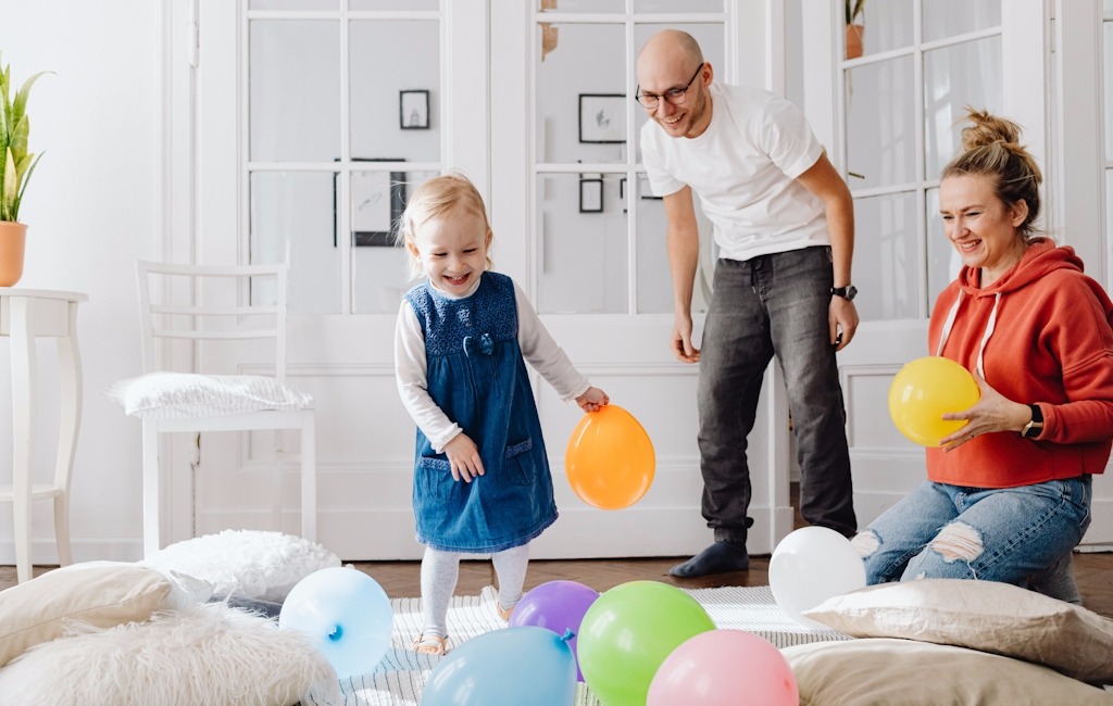Familie mit Kind spielen mit Ballons