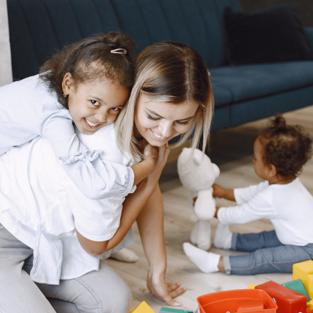 Tagesmutter spielend mit Tageskindern